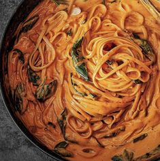 a pan filled with pasta and sauce on top of a table