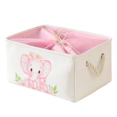 a pink and white storage box with an elephant design on the front, tied in twine