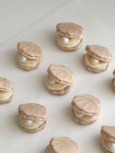 several cookies with white frosting and macaroni shells on a sheet of paper