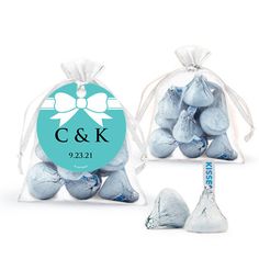 two bags filled with blue and white chocolate candies next to one bag containing the initials c & k