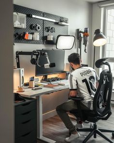 a man sitting at a desk in front of a computer monitor on top of a chair