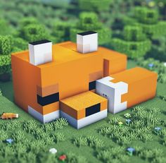 an orange and white animal sitting on top of a lush green field