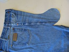 an old pair of blue jeans laying on top of a white surface with a tag in the pocket