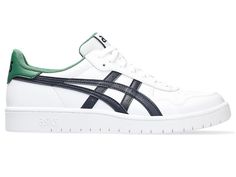 a white and green sneaker with the word asics on the upper half of it