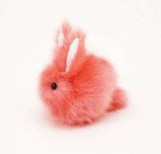 a pink stuffed animal rabbit sitting on top of a white surface