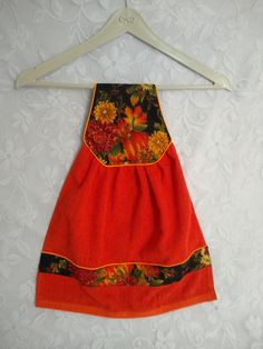 an orange dress hanging on a white wall