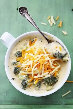 a bowl of soup with cheese and broccoli