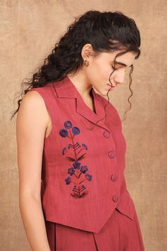 Earthy red sleeveless lapel collar vest with multi thread blossom embroidery on one side. Paired with a matching pant. - Aza Fashions Fitted Cotton Vest With Floral Embroidery, Spring Embroidered Sleeveless Vest, Sleeveless Embroidered Spring Vest, Embroidered Sleeveless Vest For Spring, Spring Sleeveless Embroidered Vest, Red Sleeveless Tops With Floral Embroidery, Red Sleeveless Top With Floral Embroidery, Sleeveless Red Tops With Floral Embroidery, Sleeveless Embroidered Vest For Spring