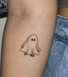 a small ghost tattoo on the arm