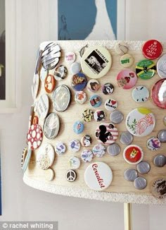 a lamp shade covered in buttons and magnets