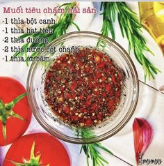 a bowl filled with lots of seasoning next to tomatoes