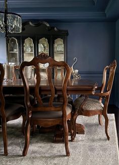 a dinning room table with chairs and a china cabinet in the back ground area