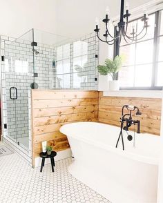 a white bath tub sitting in a bathroom next to a walk in shower