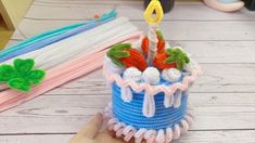 a hand is holding a small crocheted birthday cake