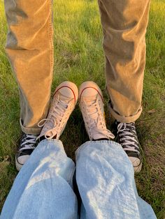 two people standing next to each other in the grass