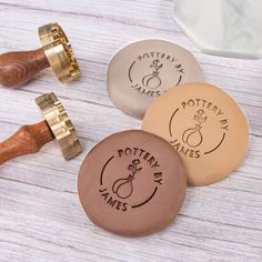 three different types of personalized wooden stampers on a white table with wood handles