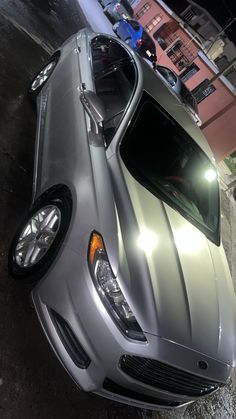 a silver car is parked on the side of the street