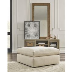 a white ottoman sitting on top of a wooden floor next to a mirror and dresser