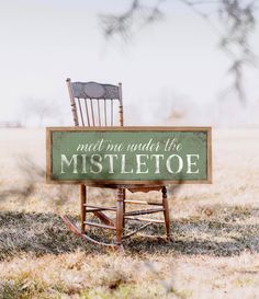 an old rocking chair with a sign that says meet me under the mistletoe