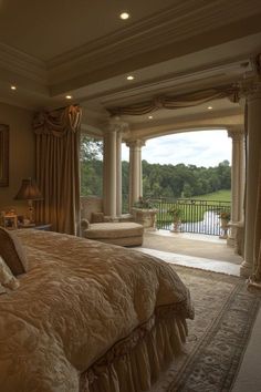 a large bed sitting in the middle of a bedroom next to a window with curtains