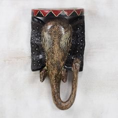 an elephant's head is mounted to the wall with decorative decorations on it,