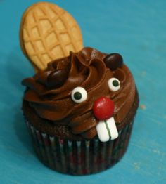 a cupcake with chocolate frosting and a cookie in the shape of a face