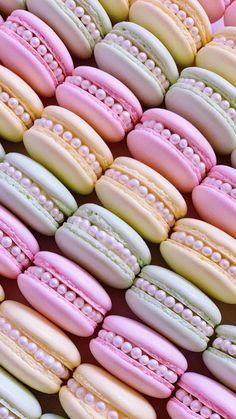 macaroons are arranged in pastel colors with pearls on them