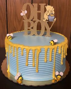 a blue cake with yellow icing and some honeybees on the top,