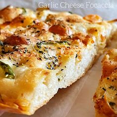 a close up of a slice of pizza on a paper towel with the words garlic cheese focaccia