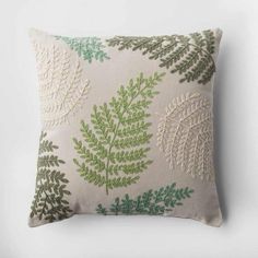 a green and white pillow with leaves on it