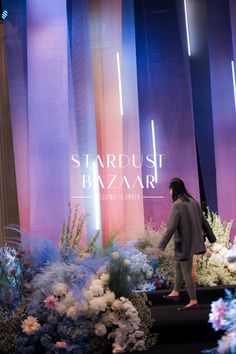 a woman standing in front of a display of flowers