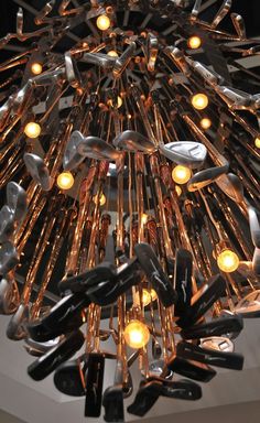 a chandelier made out of forks and knives hanging from it's ceiling