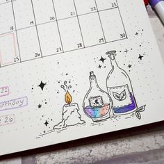 a calendar with two bottles on it next to a candle and some writing utensils