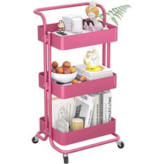 a pink rolling cart with three shelves filled with books and other things on it's wheels