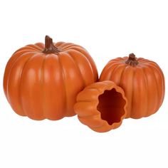 two pumpkins sitting next to each other on a white background