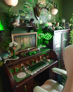 a desk with a computer on top of it in a room filled with plants and decorations