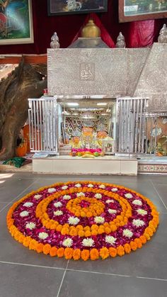 an elaborate flower arrangement on the floor in front of a shrine