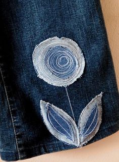 a pair of jeans with embroidered flowers on them