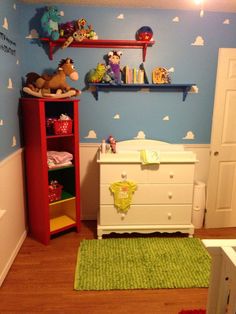 a baby's room with blue walls and white furniture