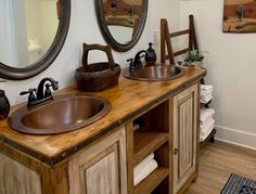 a bathroom with two sinks and mirrors on the wall next to a wooden counter top