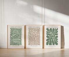 three books are sitting on the floor in front of a white wall and wooden floors