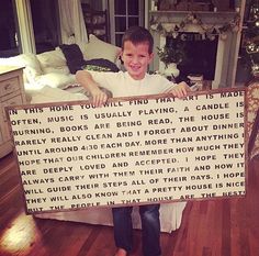 a young boy holding up a sign with words written on it