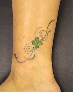 a woman's foot with a clover tattoo on it