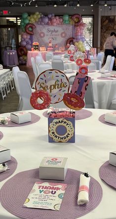 the table is set up with donuts, candy and napkins for someone's birthday party