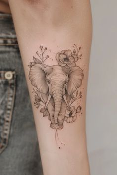 an elephant and flowers tattoo on the arm