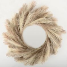 a white and brown fur wreath sitting on top of a table next to a clock