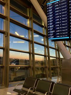 there is a large screen on the wall in an airport terminal that displays flight times