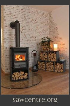 a wood burning stove in a living room next to stacks of firewood on the floor