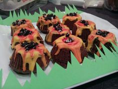 chocolate desserts with orange frosting and sprinkles on a green plate