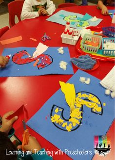 children are sitting at a table making crafts